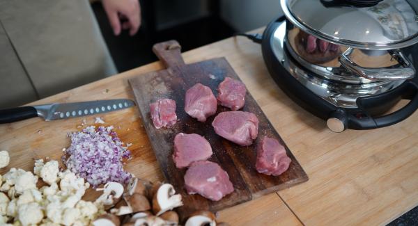 Den Blumenkohl, Zwiebeln und die Champignons klein schneiden. Anschließend das Schweinefilet in ca. 5cm dicke Stücke schneiden. Danach das Schweinefilet gut von beiden Seiten mit Salz würzen.