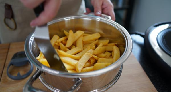 Sobald die 5 Minuten abgelaufen sind, die Pommes einmal gut durchmischen.