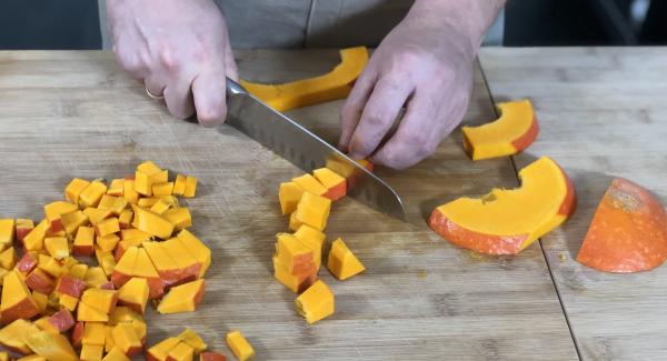 Den Kürbis in Würfel schneiden (insgesamt braucht man 500g schon geschnittenen Kürbis). Anschließend die Zwiebeln, Paprika und die Knoblauchzehe schneiden.