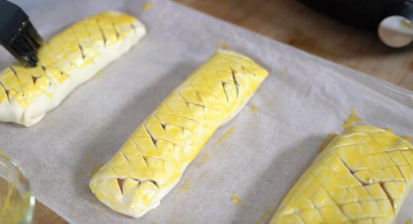 Die Lachsfilet-Stücke mit Eigelb bestreichen.