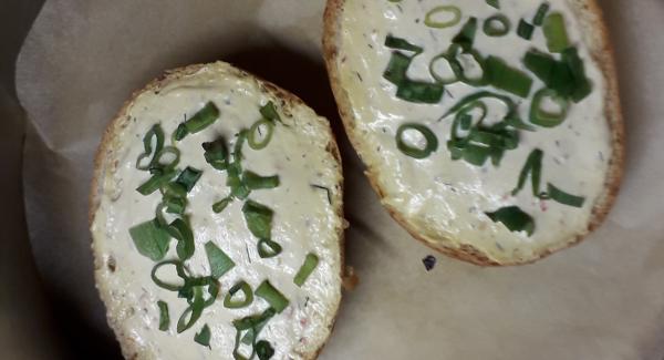 In der Zwischenzeit die Brötchen mit etwas Wasser befeuchten und mit einem Messer aufschneiden. Dann mit einem Frischkäse deiner Wahl die Brötchen schmieren. Dies sollte etwas dicker als üblich sein. Das Grüne der Frühlingszwiebel abschneiden, waschen, klein schneiden und auf die geschmierten Brötchenhälften verteilen.