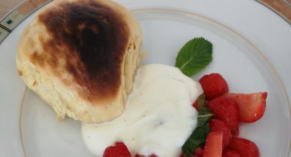 Falls gewünscht , kurz goldbraun überbacken. Erdbeeren, Creme und Dampfnudel auf Teller anrichten.