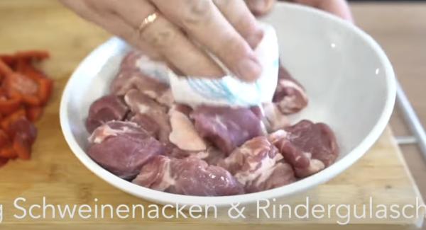 In der Zwischenzeit den Schweinenacken und den Rindergulasch mit einem Serviette trocken tupfen. Anschließend das Fleisch gut mit Salz salzen.