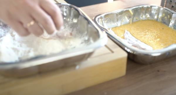 Die Hähnchenstücke von beiden Seiten in Mehl wälzen. Anschließend das Hähnchen in die Ei-Parmesan-Masse legen.