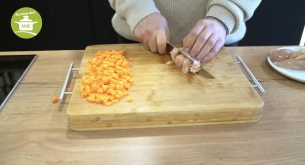 In der Zwischenzeit Hähnchen in Mundgerechte Stücke schneiden.