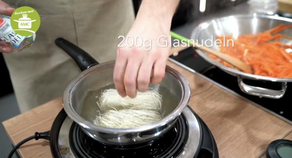 Topf mit dem Wasser für die Nudeln erhitzen. Dabei darf das Wasser NICHT kochen. Die Glasnudeln sollten komplett mit Wasser bedeckt sein, dann nach Packungsanleitung im heissen Wasser ziehen lassen.