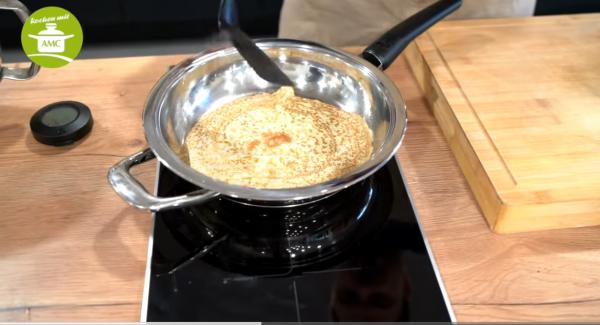 Eine Schöpfkelle Teig in die Pfanne gießen und den Pfannkuchen ausbacken und dann wenden.