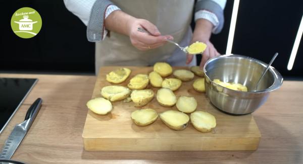 Kartoffeln aus dem Wasser rausnehmen, aufschneiden und aushöhlen.